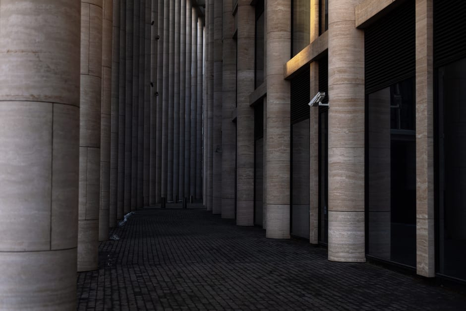 Contemporary colonnade corridor with tall columns and dramatic lighting effects.
